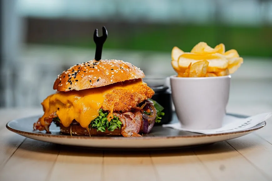 Burger und Pommes aus der bisherigen garage-Küche, auf einem Keramikteller angerichtet.